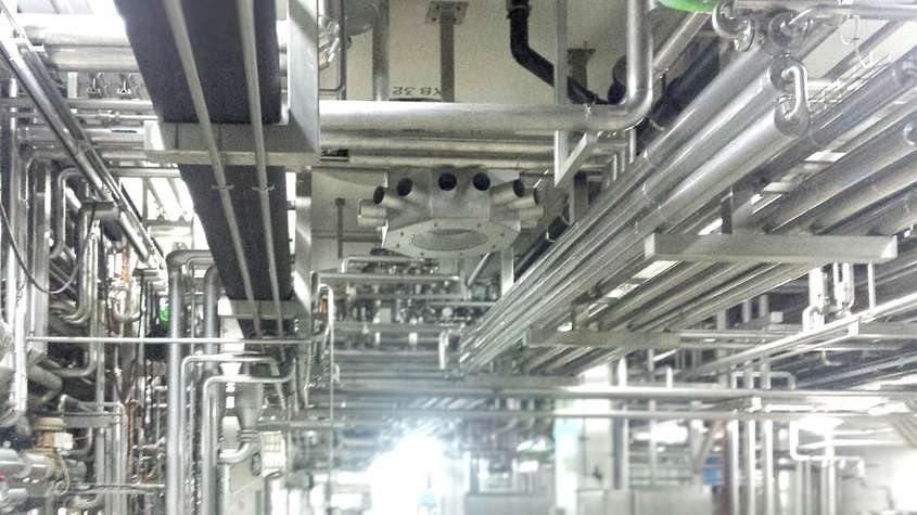 ESJET-F Klimagerät zwischen Rohrleitungen in einer Produktionshalle