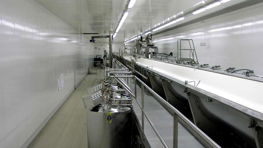 KOAGULATORRAUM EDEWECHT Ein steriler Raum voller technischer Geräte und einem langen, offenen Rohr mit einem Strom aus Milch