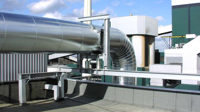 A large stainless steel pipe on the roof of a building