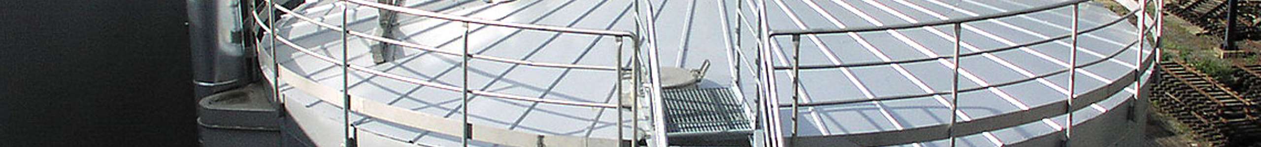 Ein großes Silo mit einer Treppe aus Metall. Etwas Dampf ströhmt aus einem Rohr an der Spitze des Silos