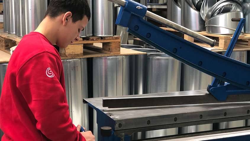 Sheet metal processing A young man working with a sheet metal processing machine