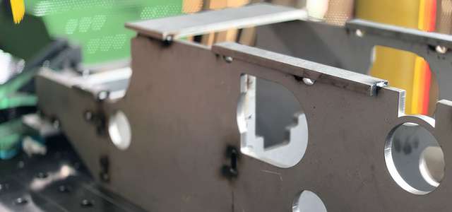Close-up of a metal workpiece with circular cutouts