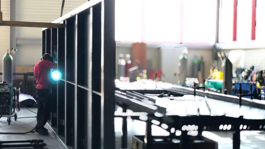 Stahlbau Maschinenbau Ein Mann beim Schweißen einer Metallwand in einer Werkstatt