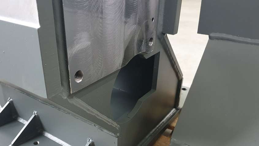 Stahlbau Maschinenbau Bohr-Fräsbearbeitung Close-up eines Metallteils mit einem kreisförmigen Ausschnitt, der in ein Rechteck übergeht